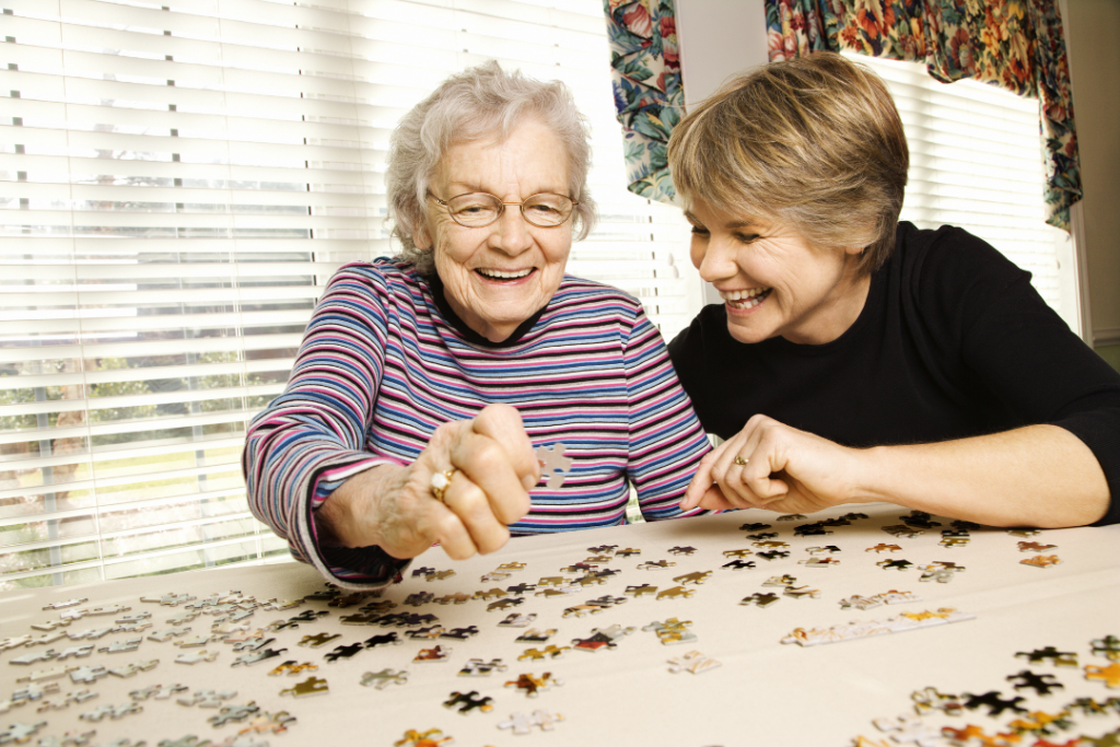 elderly mother doing a puzzle with daughter